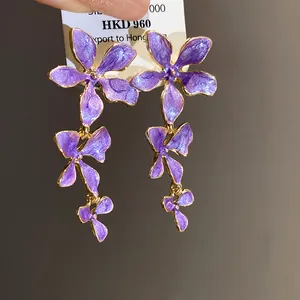 Elegante lila Emaille-Blumen-Ohrhänger mit goldfarbenen Akzenten und feinem Blumendesign