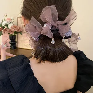 Vue détaillée d'un chouchou en mousseline violette avec des gouttes de cristal