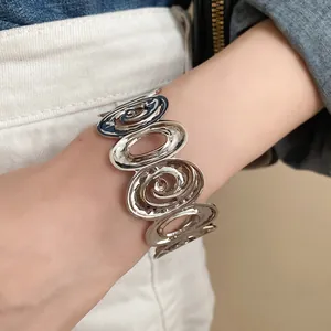 Detail shot of a silver irregular hollow-out spiral open cuff bracelet for women