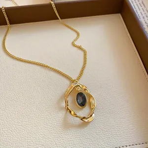 Close-up of vintage gold twisted pendant necklace with oval blue gemstone detail