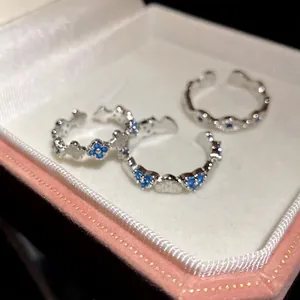 Silver heart open rings set with blue zircons in a pink jewelry box
