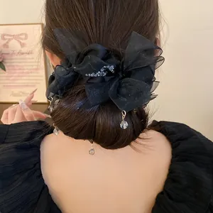 Vue détaillée du chouchou élégant avec nœud en mousseline noire et perles cristal