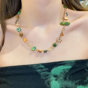 Primo piano di una collana vintage di perle di conchiglia irregolari su una modella elegante.