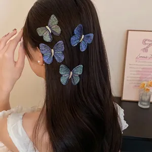 Elegant blue and green embroidered butterfly hair clips on model's long dark hair