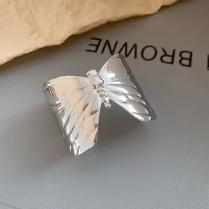 Detailed shot of silver irregular wrinkled butterfly open cuff with elegant metallic luster