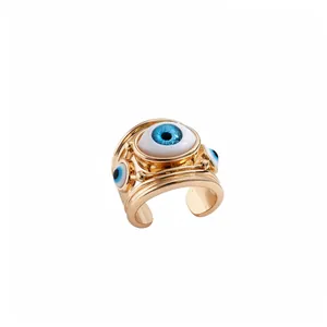 Anello aperto dorato con dettagli in resina blu malocchio per un look bohémien chic
