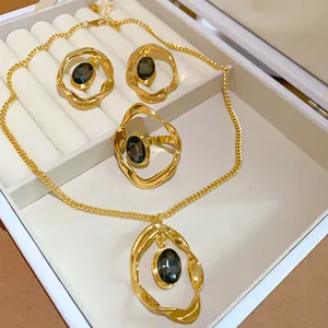 Close-up detail of a vintage jewelry set featuring oval dark gems and wrinkled gold frames.