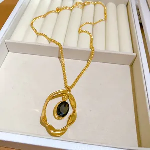 Vintage gold oval necklace featuring a textured wrinkled pendant with a dark gemstone