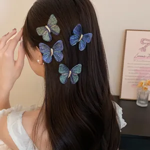 Detail shot of four colorful embroidered butterfly hair clips in long dark hair