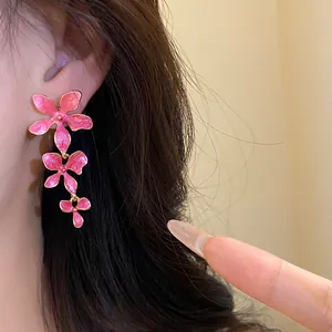 Detailansicht der eleganten rosa Emaille-Blumen-Quasten-Ohrhänger am Ohr des Models