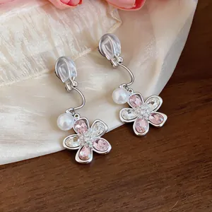 Detail view of elegant flower-shaped clip-on earrings with pink crystals and pearls
