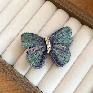 Macro detail of a vintage knitted butterfly hair clip with blue gradient wings