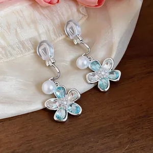 Detailed macro shot of the light blue crystal flower and pearl clip-on earrings