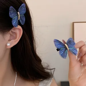 Detailed close-up showing the blue knitted butterfly hair clip with gold center detail