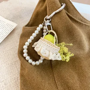 Detail of French style pearl bead bag charm with mini lace basket and green apple