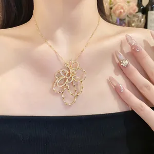 Elegante collana con pendente a fiore cavo in zircone placcato oro 18 carati su una modella