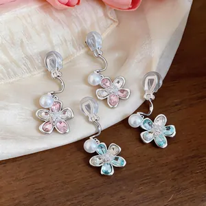 Detailed view of floral clip-on earrings with crystals and pearls in pink and blue