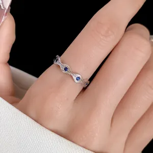 Macro detail of an elegant wavy silver ring set with sparkling blue zircon stones