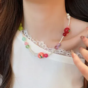 Delicate French style resin apple beaded pearl necklace worn by a model in detail view