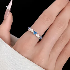 Close-up detail of an elegant silver zircon heart open ring worn on a woman's finger