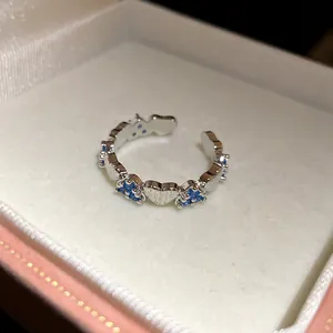 Exquisite detail of silver heart open ring with blue zircon stones in a pink gift box