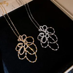 Dettaglio di due collane a fiore traforate placcate oro 18k con zirconi cubici