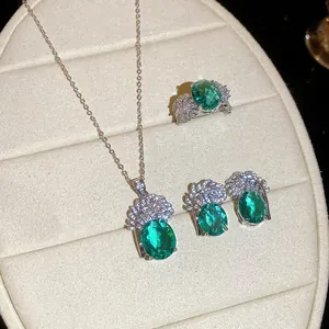 Primo piano di un set di gioielli vintage con pietre verde smeraldo e piume