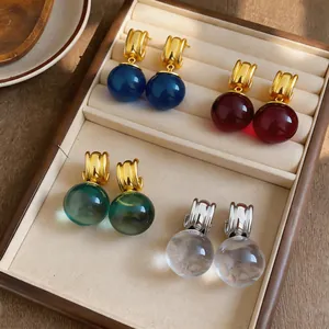 Close-up van vintage hars oorbellen in verschillende kleuren gepresenteerd in een doosje