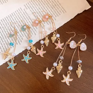 Macro detail view of elegant nautical earrings with shell, starfish and pearl charms