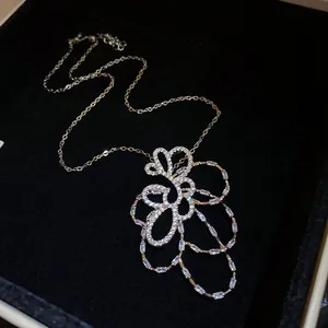 Primo piano di una collana con ciondolo a fiore traforato placcato in oro 18 carati