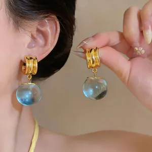 Gedetailleerde opname van retro hars oorbellen met blauwe ronde hangers luxe stijl.