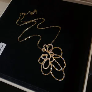 Vista dettagliata del ciondolo a fiore traforato placcato oro 18k con zirconi lucidi