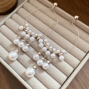 Detailed close-up of elegant French vintage hoop earrings with tiered pearl tassels.