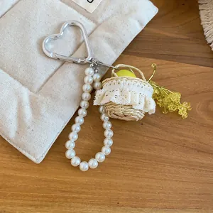 Detailed close-up of a French style pearl beaded keychain with a mini lace straw basket charm