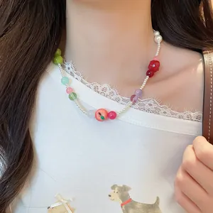 Detailed view of the French style resin apple charm and colorful beaded pearl necklace