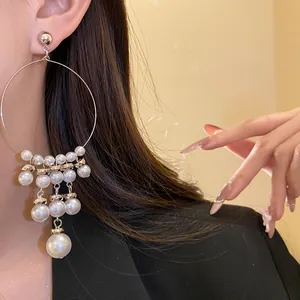 Detail view of French vintage silver hoop earrings with tiered pearl tassels on model