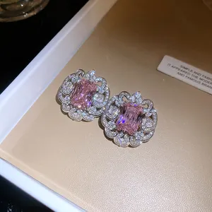 Gros plan de boucles d'oreilles en zircon rose avec bordure florale en dentelle