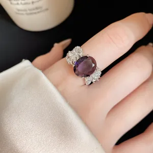Dettaglio macro di un anello in zircone viola ovale retrò con ali di piuma in argento