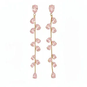 Eleganti orecchini a foglia con zirconi rosa e nappe dorate su sfondo bianco neutro