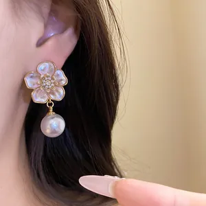 Close-up of an elegant flower stud earring featuring a zircon center and a pearl drop