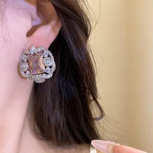 Gros plan de boucles d'oreilles en zircone rose avec une dentelle argentée fine