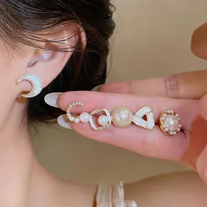 Detail shot of elegant pearl and rhinestone earring set with crescent moon design