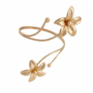 Elegant gold-tone metal open arm cuff bracelet featuring two detailed floral motifs.