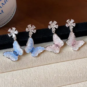 Eleganti orecchini a lobo a farfalla e fiori in zircone in tonalità blu e rosa scintillanti.