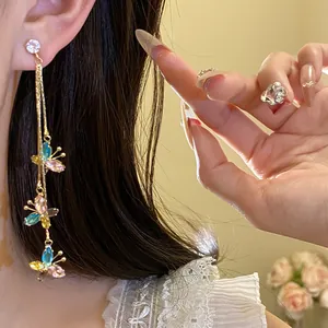Primo piano dettagliato di eleganti orecchini a nappa con farfalla in zircone e argento