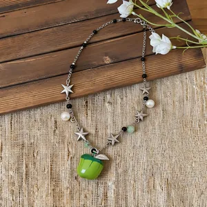 Exquisite close-up of a sweet green apple pendant necklace with stars and pearls