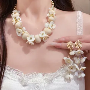 Close-up of acrylic beaded flower necklace and matching earrings on a model