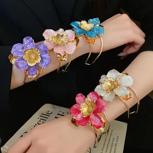 Close-up detail of luxury vintage style metal drip glaze flower bangles on model