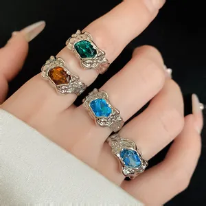 Macro view of irregular pleated silver rings featuring vibrant colorful crystal gemstones