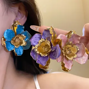 Detailed view of colorful vintage enamel flower stud earrings with golden accents.
